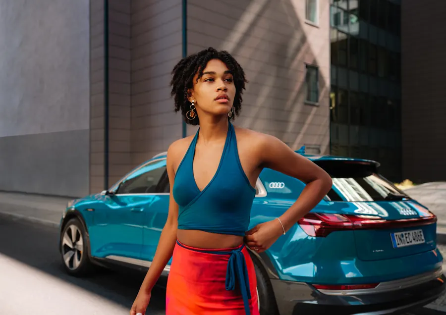 Model mit blauem E-SUV in der Stadt
